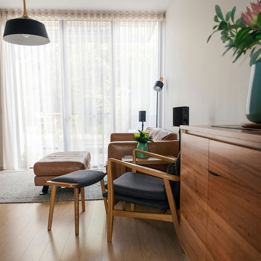 View of a beautiful mid-century living room with floor to ceiling sheer curtains