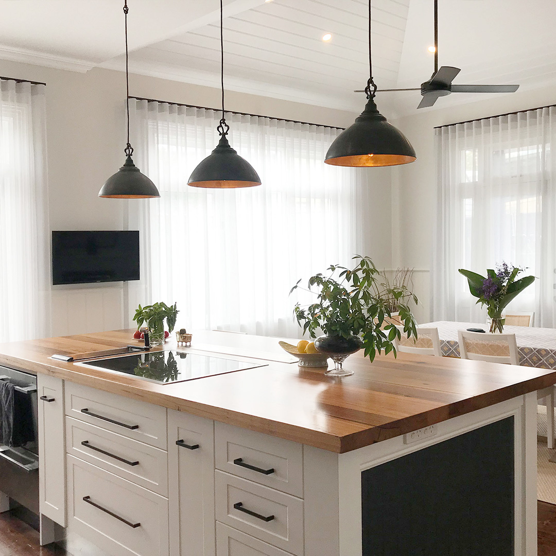 Light grey sheer curtains with black tracks, looking from the kitchen into the dining room of a heritage home. 