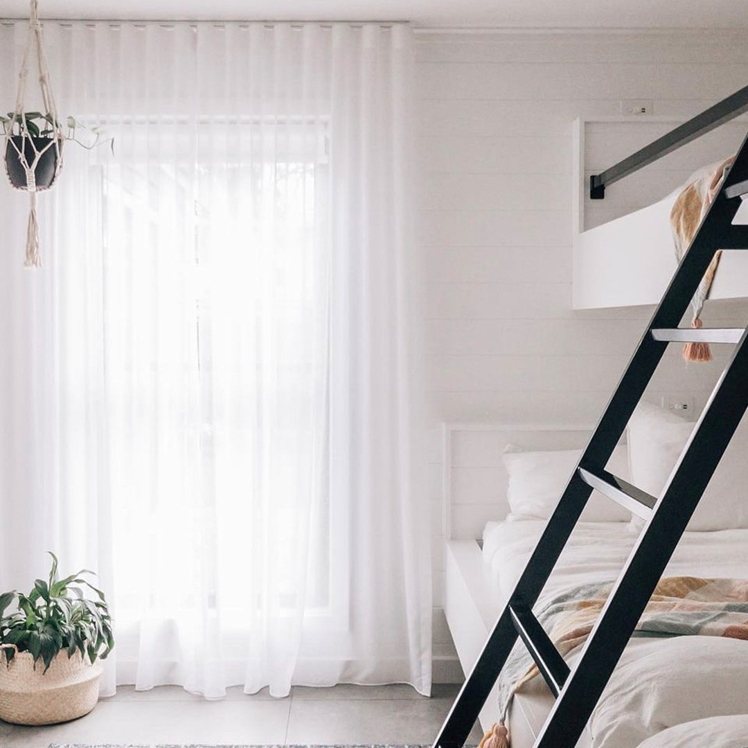 Beautiful white sheer curtains in the kids bunkroom of a holiday house.